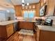 Modern kitchen features wood cabinets, stainless steel appliances, granite countertops, and hardwood floors at 14 Cypress Run, Haines City, FL 33844