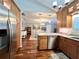 Modern kitchen boasts stainless steel appliances, wooden cabinetry, granite countertops, and a hardwood floor at 14 Cypress Run, Haines City, FL 33844