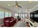 Bright living room featuring coffered ceiling, wood floors, modern fan and comfortable seating at 14 Cypress Run, Haines City, FL 33844