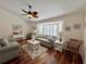 Cozy living room with hardwood floors, ceiling fan, and plantation shutters at 14 Cypress Run, Haines City, FL 33844