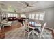 Open concept living room and dining room with wood floors, ceiling fans and gray rug at 14 Cypress Run, Haines City, FL 33844