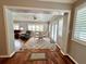 View through the archway into the living room, featuring wood floors and bright natural lighting at 14 Cypress Run, Haines City, FL 33844