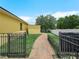 A backyard featuring a charming brick pathway, fencing, and a lush green lawn at 147 Brookshire Dr, Lake Wales, FL 33898