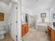 Well-lit bathroom with a shower, soaking tub, double sinks, and neutral tile flooring at 147 Brookshire Dr, Lake Wales, FL 33898