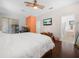 Bright bedroom featuring wood floors, a ceiling fan, and an adjacent bathroom with a soaking tub at 147 Brookshire Dr, Lake Wales, FL 33898