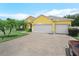 Bright yellow home featuring a paved driveway leading to a two-car garage and lush green lawn at 147 Brookshire Dr, Lake Wales, FL 33898