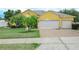 Charming yellow house with a well-manicured lawn, mature palm trees, and a two-car garage at 147 Brookshire Dr, Lake Wales, FL 33898