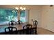 Bright dining room with wood table and chairs plus a large window providing natural light at 150 El Dorado # 109, Winter Haven, FL 33884