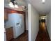 Hallway with wood floors connecting to kitchen with granite countertops and stainless refrigerator at 150 El Dorado # 109, Winter Haven, FL 33884