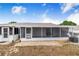 Enclosed patio space featuring screened walls, a brick floor, and adjacent white vinyl room with access door at 151 Winter Ridge Dr # 151, Winter Haven, FL 33881