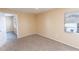 A bright bedroom features neutral carpet, window, and soft, neutral color palette at 1550 11Th Ne St # E7, Winter Haven, FL 33881