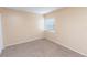 Well-lit bedroom with plush carpeting, window, and soft neutral color palette at 1550 11Th Ne St # E7, Winter Haven, FL 33881