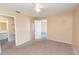 Spacious bedroom featuring plush carpet, ceiling fan, adjoining bathroom, and soft neutral color palette at 1550 11Th Ne St # E7, Winter Haven, FL 33881