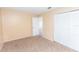Bright bedroom featuring neutral walls, carpeted floors, and a closet with folding doors at 1550 11Th Ne St # E7, Winter Haven, FL 33881