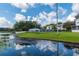 View of community pool next to the lake for community members' leisure and enjoyment on a bright sunny day at 1550 11Th Ne St # E7, Winter Haven, FL 33881