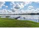 Lakeside view with a private dock and well-maintained green lawn at 1550 11Th Ne St # E7, Winter Haven, FL 33881
