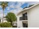 Condo exterior showing palm trees, blue sky, and a balcony with black railings at 1550 11Th Ne St # E7, Winter Haven, FL 33881