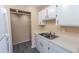 Kitchen features white cabinetry, double sink, and gray wood-look floors at 1550 11Th Ne St # E7, Winter Haven, FL 33881