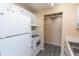 Kitchen showcasing white appliances, wood-look floors, and closet storage space at 1550 11Th Ne St # E7, Winter Haven, FL 33881