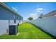 Well-maintained backyard featuring lush green grass, a white privacy fence, and a Goodman AC unit at 157 Walkers Point Dr, Auburndale, FL 33823