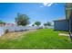 Wide backyard featuring lush green grass, a white fence, and mature trees, perfect for outdoor recreation at 157 Walkers Point Dr, Auburndale, FL 33823
