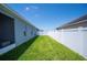 Narrow backyard with a well-manicured lawn and a white privacy fence, offering a secure and private space at 157 Walkers Point Dr, Auburndale, FL 33823