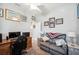 Cozy room featuring neutral walls, ceiling fan, recliner, desk, and a collection of framed art pieces at 157 Walkers Point Dr, Auburndale, FL 33823