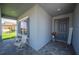Cozy front porch featuring stylish seating and a welcoming entrance to a well-maintained home with manicured landscaping at 157 Walkers Point Dr, Auburndale, FL 33823