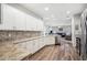 Open kitchen with stainless appliances, white cabinets and backsplash, with a view to the living room at 157 Walkers Point Dr, Auburndale, FL 33823