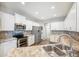 Bright kitchen with white cabinets, stainless steel appliances, designer backsplash and updated sink at 157 Walkers Point Dr, Auburndale, FL 33823