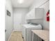 Laundry room with front load washer and dryer, storage cabinets, and utility sink at 157 Walkers Point Dr, Auburndale, FL 33823