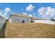 View of the backyard showing the lawn, fence, and exterior of the house at 180 Grove Branch Rd, Winter Haven, FL 33880
