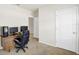 Neutral carpeted bedroom with a desk and view to the hallway and out a window at 180 Grove Branch Rd, Winter Haven, FL 33880