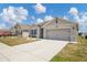 Single-story home with a driveway, neutral exterior, and manicured landscaping at 180 Grove Branch Rd, Winter Haven, FL 33880