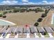 Street view showcasing a neat row of modern homes with well-kept lawns, driveways, and a glimpse of green fields at 180 Grove Branch Rd, Winter Haven, FL 33880