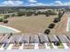 Street view showcasing a neat row of modern homes with well-kept lawns, driveways, and a glimpse of green fields at 180 Grove Branch Rd, Winter Haven, FL 33880