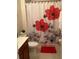 Bathroom with floral shower curtain, vanity, toilet, and tiled floor at 1820 Coriander Dr, Poinciana, FL 34759