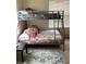 Comfortable bedroom with a bunk bed, bright bedding, and a patterned area rug at 1820 Coriander Dr, Poinciana, FL 34759