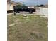 View of the home's front yard, featuring a black truck in the driveway on a cloudy day at 1820 Coriander Dr, Poinciana, FL 34759
