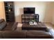 Comfortable living room with brown leather sofa, entertainment center, and a plush ottoman at 1820 Coriander Dr, Poinciana, FL 34759