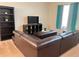 Spacious living room featuring a comfortable brown sectional sofa and a TV with shelving at 1820 Coriander Dr, Poinciana, FL 34759