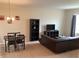 Open-concept living area with dining table, sofa, entertainment center, and natural light at 1820 Coriander Dr, Poinciana, FL 34759