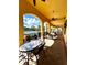A covered patio features several tables, chairs, ceiling fans and overlooks a community pool at 1820 Coriander Dr, Poinciana, FL 34759