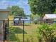 Fenced backyard with mature trees and a glimpse of the lake at 1919 19Th Nw St, Winter Haven, FL 33881