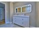 Modern bathroom featuring double sink vanity, dual backlit mirrors and neutral tile flooring at 1919 19Th Nw St, Winter Haven, FL 33881