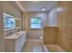 This bathroom features a double sink vanity, natural light from a window, and a tiled shower and bath at 1919 19Th Nw St, Winter Haven, FL 33881