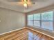 Bright bedroom featuring refinished hardwood floors, a ceiling fan and large windows at 1919 19Th Nw St, Winter Haven, FL 33881