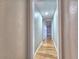 A hallway with hardwood floors and neutral paint, leading to other rooms at 1919 19Th Nw St, Winter Haven, FL 33881