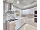 Modern kitchen featuring white cabinets, stone backsplash, and stainless steel range hood at 1919 19Th Nw St, Winter Haven, FL 33881