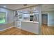 Bright, open kitchen with white cabinets, island, stainless appliances, and hardwood floors at 1919 19Th Nw St, Winter Haven, FL 33881